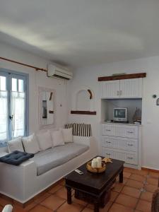 Una sala de estar con un sofá blanco y una mesa. en Serifos house, en Serifos Chora