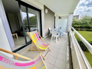 a patio with a table and chairs on a balcony at Appartement moderne 2 pièces avec grand balcon à Étel, proche plage - FR-1-479-166 in Étel