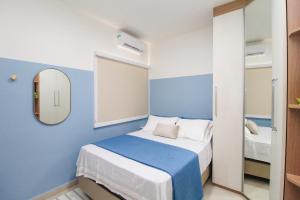 Dormitorio azul y blanco con cama y espejo en Suíte Marajó, en Belém 14 fotos más