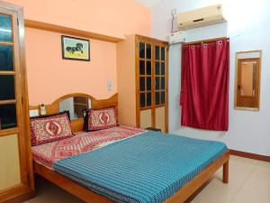 a bedroom with a bed with a red curtain at Helios Villa in Auroville +29 photos