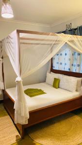 a bed with a canopy in a room at parachichi house Bed and Breakfast in Arusha +23 photos