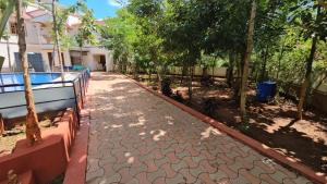 a walkway in front of a house with trees at Helios Villa in Auroville