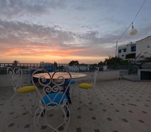 a table and chairs with the sunset in the background at Artist's House in Dar Mimoun Bey