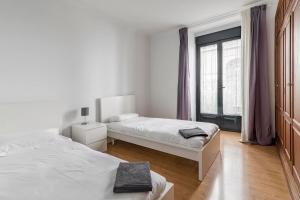 a bedroom with two beds and a window at AVE Apartamentos Madrid Centro Atocha in Madrid