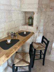 een tafel en twee stoelen met kopjes en koffie bij Nidus Petrae in Alberobello +18 foto's