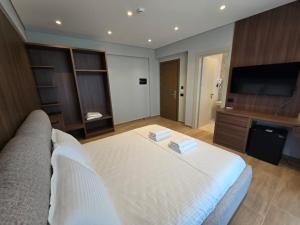 a bedroom with a large bed and a flat screen tv at Hotel Selavi in Sarandë