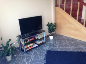 a flat screen tv sitting on a stand next to a staircase at Daja Ház in Hévíz