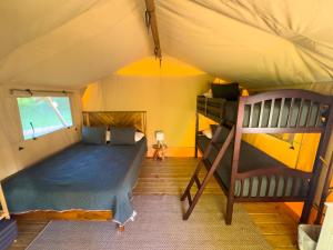 a bedroom with a bed and a bunk bed in a tent at Settle Into a Cozy Lakeside Glamping Escape in Onalaska