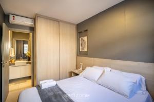 a bedroom with a white bed and a bathroom at Apart in Condo w/ Pool and Gym STE0312 in Salvador