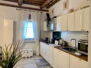 Una cocina con gabinetes blancos y una ventana. en Live As Florentine, en Florencia