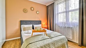 a bedroom with a bed with a table next to a window at Karpacz Residence, Sun & Snow in Karpacz