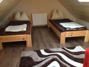 two twin beds in a attic room with a rug at Daja Ház in Hévíz