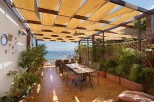 a patio with tables and chairs and a view of the ocean at Villino Dei Fiori in Ischia