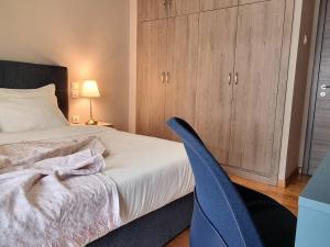 a bedroom with a bed and a blue chair at Heart of Athens 2BR Walk Everywhere in Athens