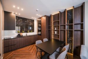 a dining room with a black table and white chairs at Ideal Apartments in Banja Luka