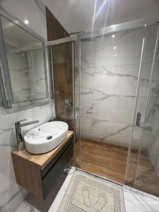 un baño con lavabo y ducha en Mitra Apartmani, en Zlatibor 6 fotos más