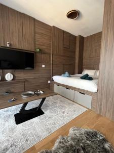 Un dormitorio con una cama y un escritorio con televisión. en Mitra Apartmani, en Zlatibor