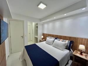 una camera da letto con un letto con lenzuola blu e bianche di In Mare Bali Apto Residencial Resort a Parnamirim Altre 37 foto
