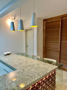 una cucina con un bancone con sedie e luci blu di In Mare Bali Apto Residencial Resort a Parnamirim