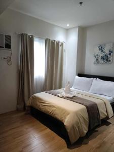 ダバオシティにある2 bedroom matina enclaves condoのタオルが敷かれたベッドのある寝室