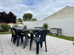 une table noire et des chaises sur une terrasse dans l'établissement Maison 3 pièces au cœur de Saint-Pierre d’Oléron, 6 couchages - FR-1-246A-359, à Saint-Pierre-dʼOléron 13 autres photos