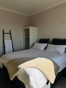 a bedroom with a large bed with white sheets at Ekuku retreat in Oshakati