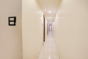 a hallway in a building with white walls and white floors at FabHotel Golden Star in Mumbai +26 photos