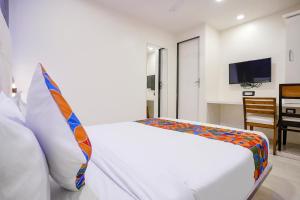 a bedroom with a white bed and a television at FabHotel Golden Star in Mumbai