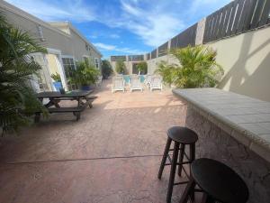 a patio with chairs and a table and a bar at Puerta del Sol 2 in Oranjestad +3 photos
