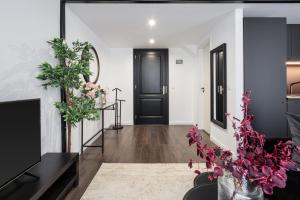 a living room with a black door and flowers at E41 - Trendy Boutique Apartments - Prime Spot by BQA in Budapest