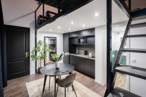 a loft apartment with a table and a kitchen at E41 - Trendy Boutique Apartments - Prime Spot by BQA in Budapest