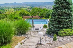a swimming pool in a garden with a stone path at Cabin Noah in Novi Marof
