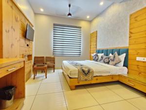 a bedroom with a king sized bed and a television at Hotel Golden Heaven Inn, Amritsar-Near Golden Temple in Amritsar