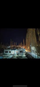 a building with trees in the background at night at Rdangsa homestay and restaurant ladakh in Leh