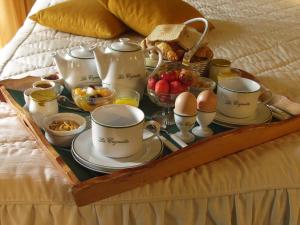 a tray of breakfast foods and eggs on a bed at HOTEL LA COGNETTE A 25 Kilomètres de Châteauroux et 30 Kilomètres de Bourges in Issoudun