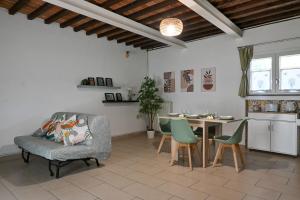 Una sala de estar con una silla y una mesa. en Inn Pisa Rentals - Cozy flat by the airport, en Pisa