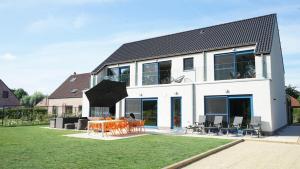 FlobecqVilla Jeanne Dusschaut的一间有桌子、椅子和遮阳伞的房子