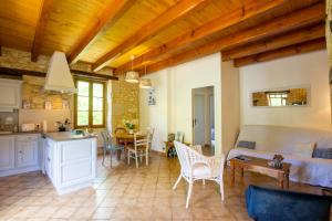 a kitchen and living room with a couch and a table at Maison périgourdine proche de Sarlat in Daglan +21 photos