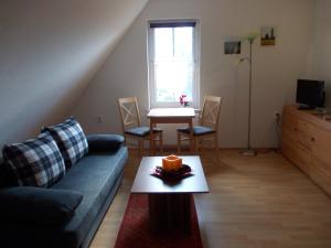 ein Wohnzimmer mit einem Sofa und einem Tisch in der Unterkunft Ferienwohnung auf Rügen ganz oben in Putgarten