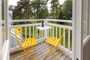 two yellow chairs and a table on a porch at Villa Rosa Harmony Apartment in Hanko in Hanko