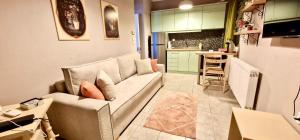 un salon avec un canapé et une cuisine dans l'établissement A Little Cosy Family Apartment, à Alexandroúpolis