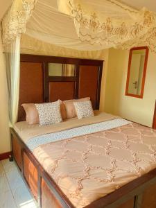 a large bed in a bedroom with a canopy at Lulu's Origo Jinja in Iganga
