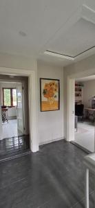 an empty living room with a painting on the wall at Nature lovers house izbeigts in Stacija Bērstele +5 photos