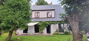 a white house with a table in a yard at Nature lovers house izbeigts in Stacija Bērstele