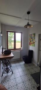 a living room with a table and a chair and a window at Nature lovers house izbeigts in Stacija Bērstele