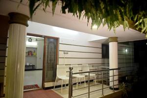 a room with a balcony with a table and chairs at K K Gardens in Palakkad