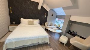 a bedroom with a bed and a table and chairs at Hotel Maria in Rădăuţi