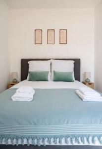 a bedroom with a blue bed with two towels on it at L'écrin rose, appartement coeur de ville de Bergerac in Bergerac