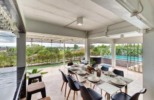 a dining room with a long table and chairs at Risa Pool Villa Nan in Ban Fai Kaeo