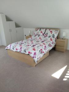 Un dormitorio con una cama con una colcha floral. en Annexe in rural idyll close to historical site, en Caerleon
